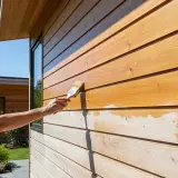 Application d'une lasure sur une fenêtre en bois, protégeant le bardage extérieur.