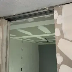 Ouverture créée pour casser un mur non porteur. Le plafond est en cours de finition avec des bandes de jointoiement.