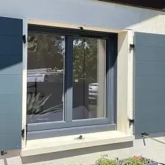 Fenêtre avec volets battants gris anthracite installés, offrant une touche moderne et sécurisée à la façade.
