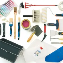 Ensemble d'outils pour papier peint : pinceaux, rouleau, truelles, spatules, seau, décolleur, ruban adhésif et nuancier.