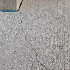 Une fissure traverse une dalle béton fraîchement coulée, témoignant des défis pour faire une dalle béton parfaite.