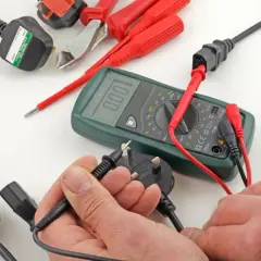 Un électricien teste des prises et un multimètre. Les dominos électriques sont interdits pour des raisons de sécurité.