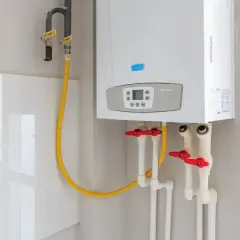 Chaudière Baxi ECO4s avec tuyauterie et vannes. Le disjoncteur chauffe-eau 16 ou 20 ampères est essentiel pour la sécurité.