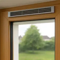 Grille d'aération discrète intégrée au cadre en bois d'une fenêtre, assurant une ventilation naturelle et constante.