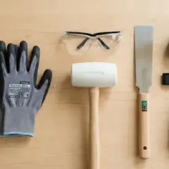 Une paire de gants, lunettes de protection, maillet, scie, mètre ruban, niveau à bulle et tournevis : des outils de base pour bricoler.