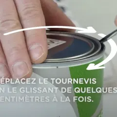 Comment ouvrir un pot de peinture : une main utilise un tournevis pour soulever le couvercle, suivant les flèches indicatrices.