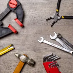 Outils divers : serre-joint, pince, clés, marteau, mètre. Une clé dynamométrique sert à serrer avec précision.