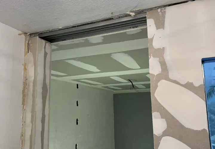 Ouverture créée pour casser un mur non porteur. Le plafond est en cours de finition avec des bandes de jointoiement.