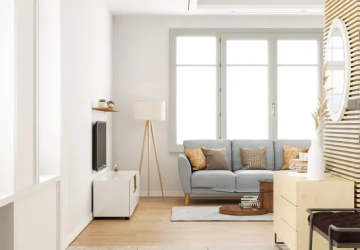 Salon lumineux avec canapé gris, table basse et grande fenêtre ouvrant à la française. Décoration moderne et épurée.