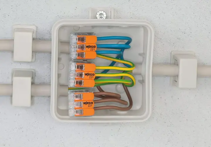 Boîte de jonction avec fils électriques connectés par des Wago 221. Apprenez comment utiliser un wago pour des connexions sûres et rapides.