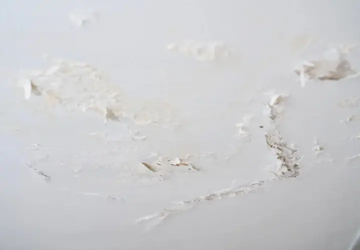 Détails d'un mur intérieur abîmé, avec des traces de salpêtre et de peinture écaillée. Une situation qui demande comment éliminer le salpêtre sur un mur intérieur.