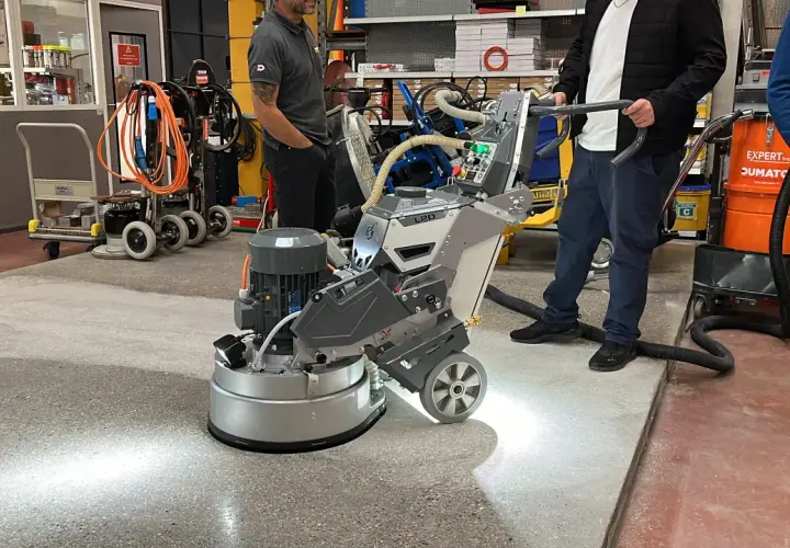 Une machine professionnelle est utilisée pour poncer du béton, créant une surface lisse et propre.