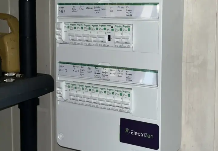 Schéma tableau électrique 3 rangées, avec disjoncteurs et étiquettes manuscrites pour identifier les circuits (cuisine, chambre, etc.).