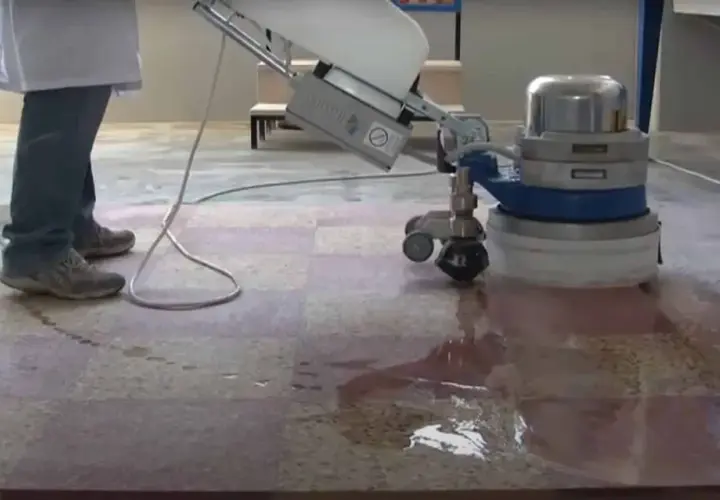 Une machine professionnelle est utilisée pour poncer le carrelage, laissant une surface propre et brillante.
