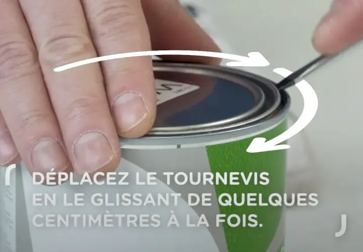 Comment ouvrir un pot de peinture : une main utilise un tournevis pour soulever le couvercle, suivant les flèches indicatrices.