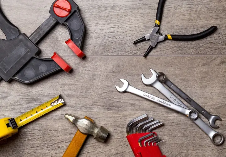 Outils divers : serre-joint, pince, clés, marteau, mètre. Une clé dynamométrique sert à serrer avec précision.