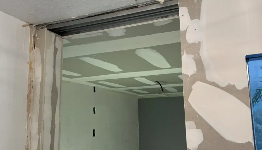 Ouverture créée pour casser un mur non porteur. Le plafond est en cours de finition avec des bandes de jointoiement.