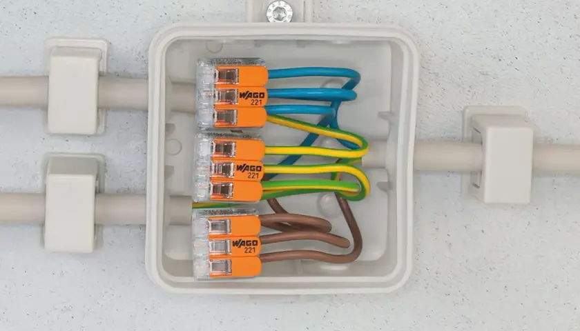 Boîte de jonction avec fils électriques connectés par des Wago 221. Apprenez comment utiliser un wago pour des connexions sûres et rapides.