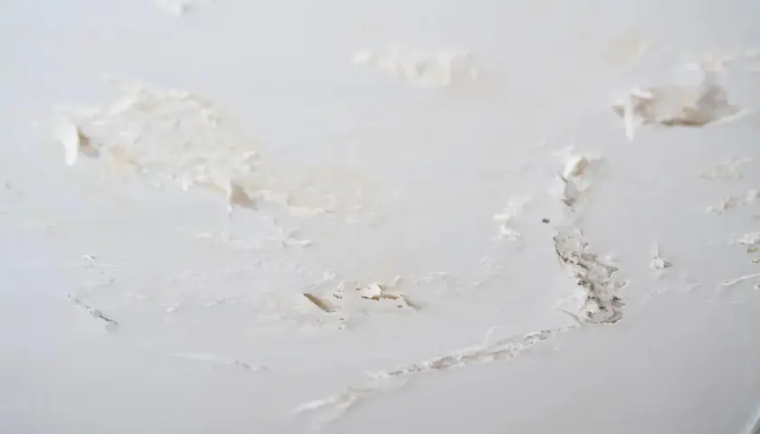 Détails d'un mur intérieur abîmé, avec des traces de salpêtre et de peinture écaillée. Une situation qui demande comment éliminer le salpêtre sur un mur intérieur.