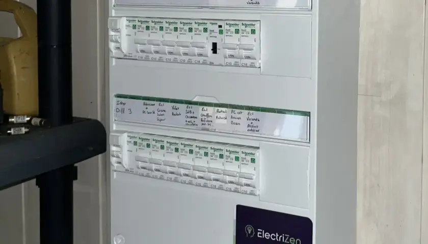 Schéma tableau électrique 3 rangées, avec disjoncteurs et étiquettes manuscrites pour identifier les circuits (cuisine, chambre, etc.).