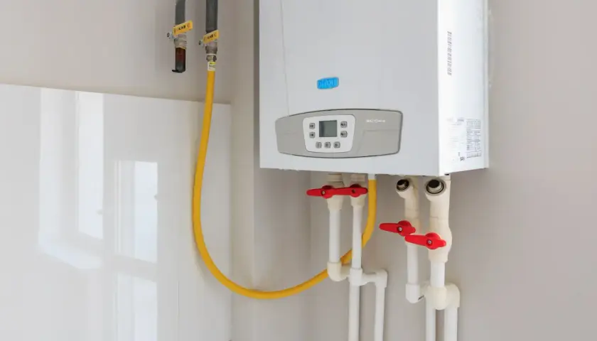 Chaudière Baxi ECO4s avec tuyauterie et vannes. Le disjoncteur chauffe-eau 16 ou 20 ampères est essentiel pour la sécurité.
