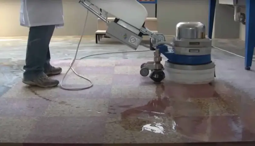 Une machine professionnelle est utilisée pour poncer le carrelage, laissant une surface propre et brillante.