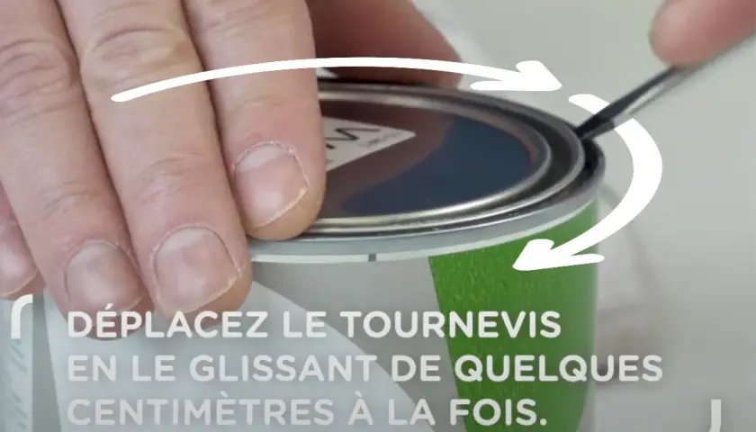Comment ouvrir un pot de peinture : une main utilise un tournevis pour soulever le couvercle, suivant les flèches indicatrices.