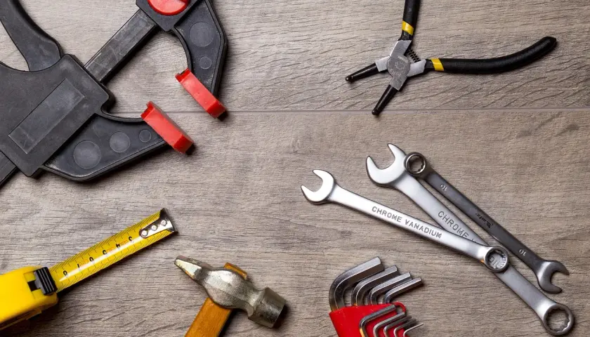 Outils divers : serre-joint, pince, clés, marteau, mètre. Une clé dynamométrique sert à serrer avec précision.