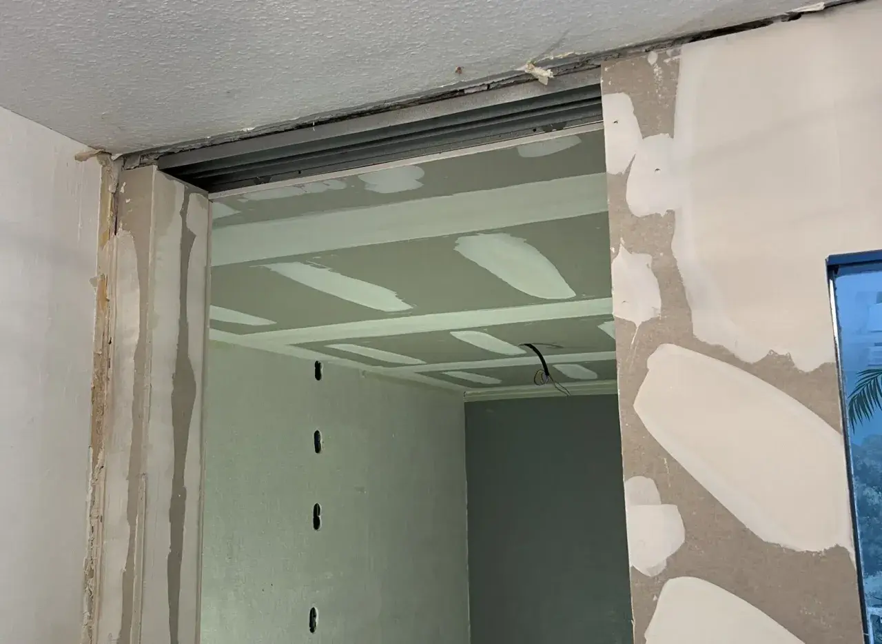 Ouverture créée pour casser un mur non porteur. Le plafond est en cours de finition avec des bandes de jointoiement.
