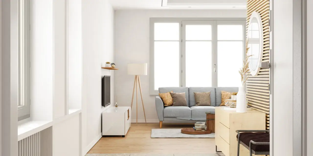 Salon lumineux avec canapé gris, table basse et grande fenêtre ouvrant à la française. Décoration moderne et épurée.