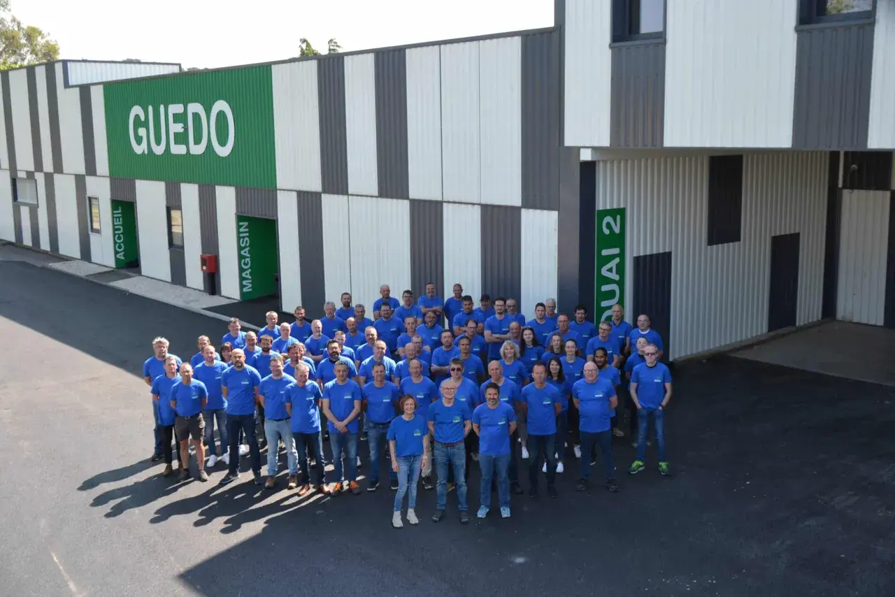 Une équipe souriante devant le bâtiment GUEDO. Avis guedo outillage : une entreprise dynamique et accueillante.