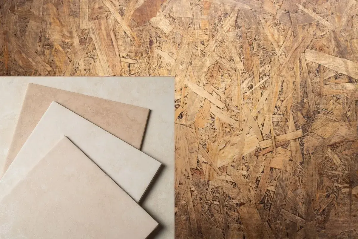 Échantillons de carrelage beige sur fond de panneau OSB, prêt pour la pose plancher.