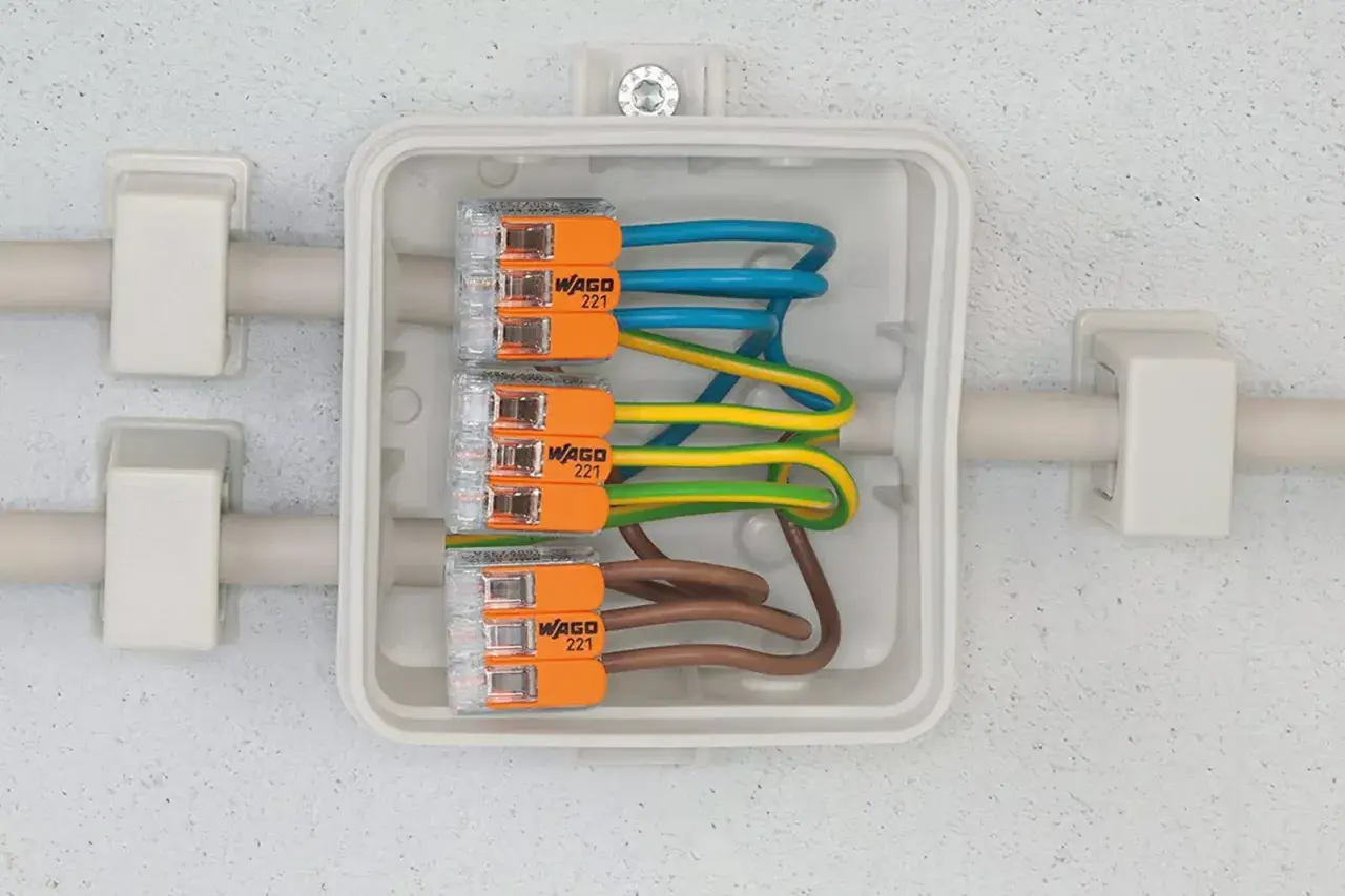 Boîte de jonction avec fils électriques connectés par des Wago 221. Apprenez comment utiliser un wago pour des connexions sûres et rapides.