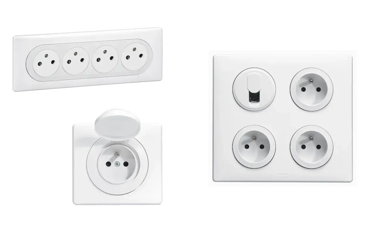 Plusieurs prises électriques blanches, dont une avec volet, pour savoir combien de prise dans une chambre.