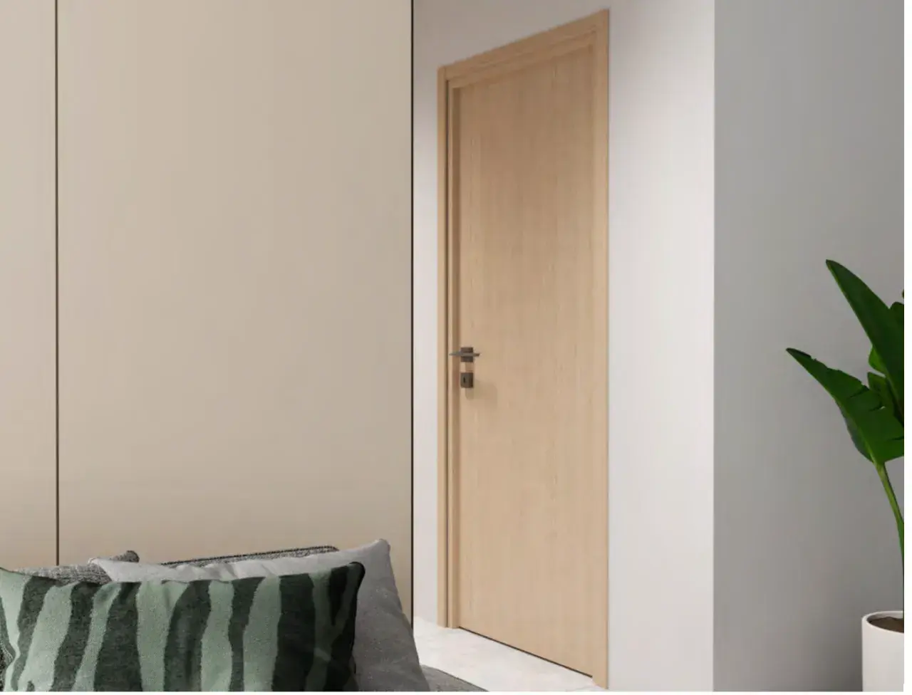 Une porte en bois clair, d'une largeur standard, s'ouvre sur un couloir. Des coussins décoratifs sont posés sur un canapé à gauche.