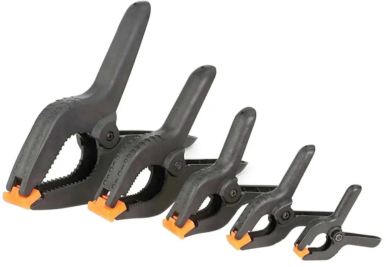 Ensemble de quatre types de pinces bricolage noires avec embouts orange, de tailles variées, prêtes pour tous vos projets.