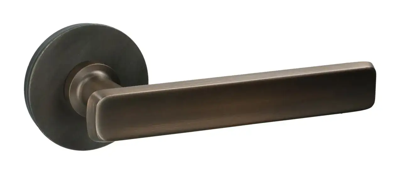 Poignée de porte moderne en bronze, au design épuré. Le carré de porte bloqué est bien visible.