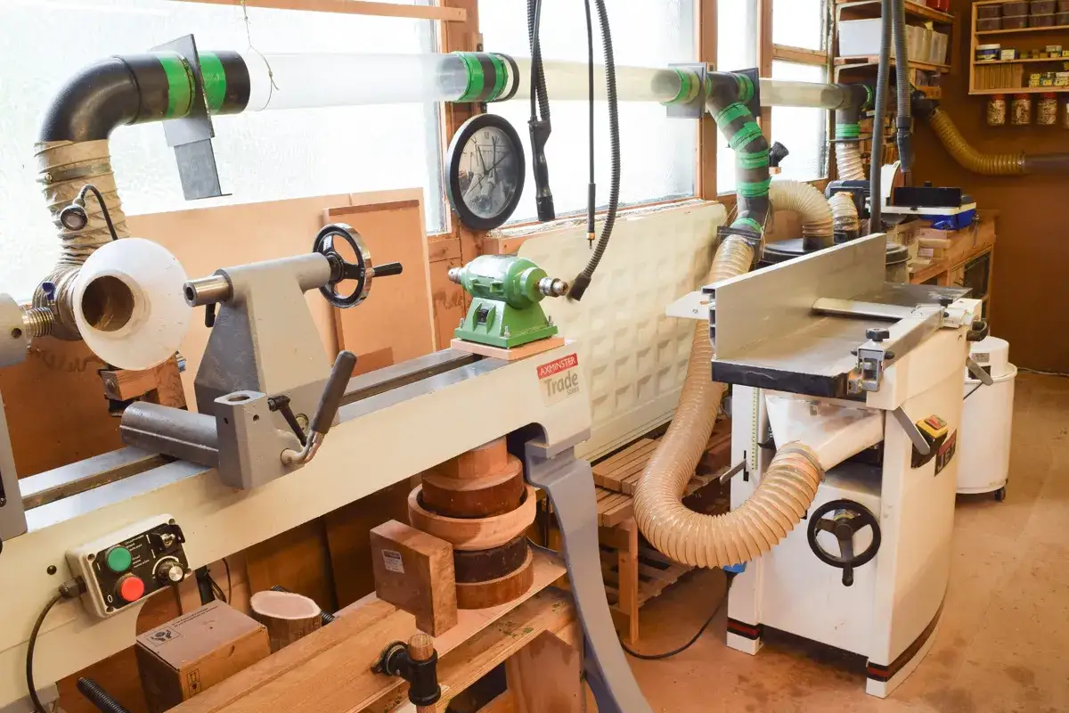 Atelier d'ébéniste avec tour à bois, dégauchisseuse et système d'aspiration. Un bel outil pour le travail du bois.