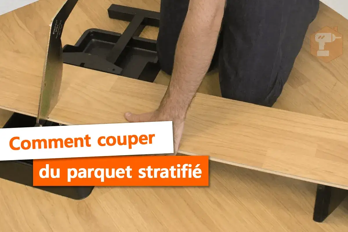 Main tenant une lame pour la coupe parquet flottant, une personne pr&eacute;pare la pose.