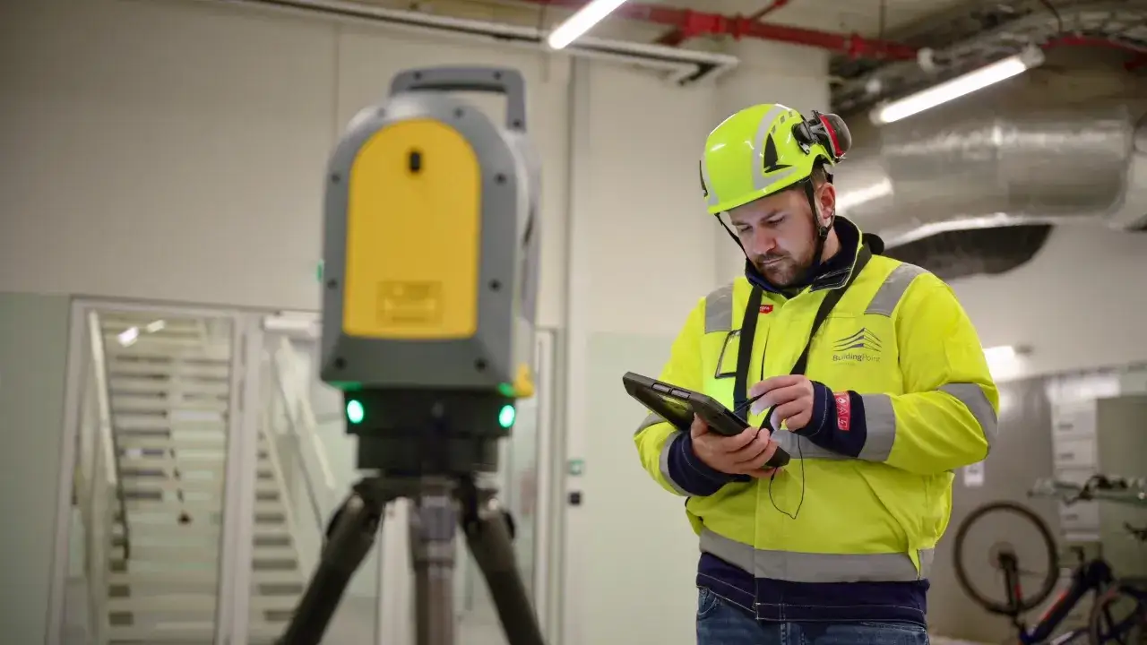 Un technicien utilise une tablette pour v&eacute;rifier le niveau laser de plan&eacute;it&eacute; du sol.