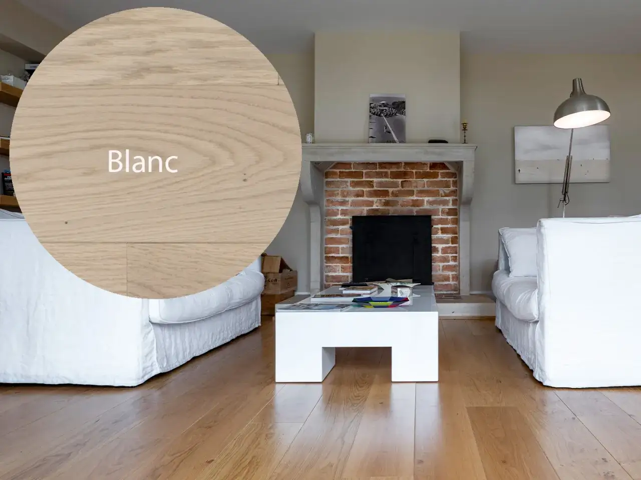 Un salon moderne avec un parquet en bois clair, id&eacute;al pour un projet de blanchir parquet. Le bois est mis en valeur par des canap&eacute;s blancs et une chemin&eacute;e en briques.
