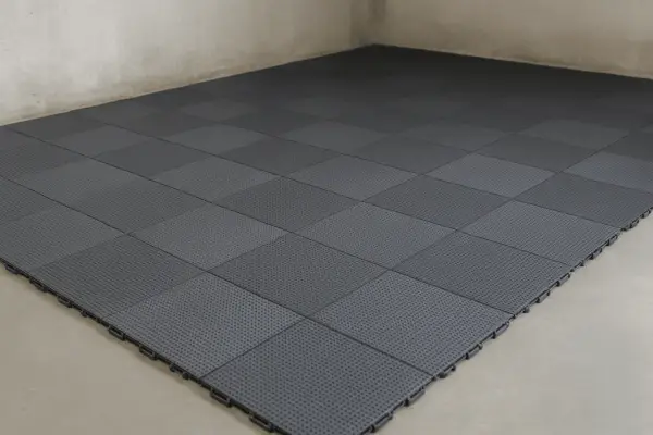 Dalles emboîtables grises pour sol de garage, offrant une solution pratique et esthétique. L'épaisseur de la dalle béton garage est ici remplacée par ce revêtement modulable.